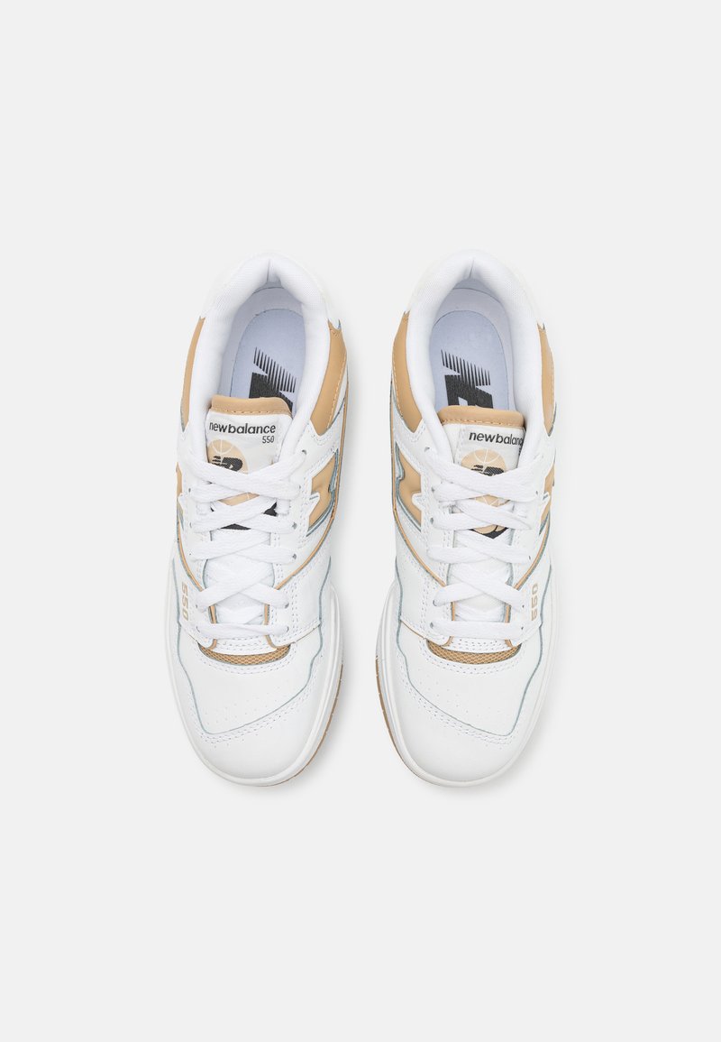 Baskets en cuir blanc avec des accents beige. Bout arrondi, col rembourré et lacets blancs. Logotype et numéro de modèle présents sur la languette.