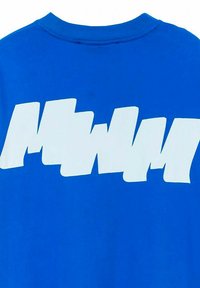 Camiseta de algodón azul con un gran gráfico abstracto blanco en la parte posterior. El diseño consiste en formas irregulares y longitudes variables.