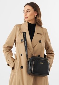 Borsa a spalla in finta pelle nera con hardware dorato, forma rettangolare, scomparti con zip e una tracolla regolabile con motivo.