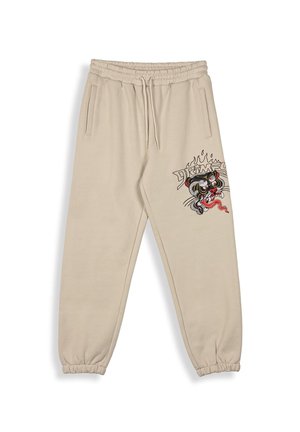 Pantalones de chándal beige con cintura y puños elásticos, que presentan un diseño gráfico colorido de un tigre y llamas en el muslo izquierdo.