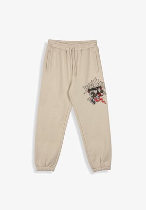 Beige sweatpants met een elastische tailleband en boorden, met een kleurrijk tijger- en vlammenontwerp op de linker bovenbeen.
