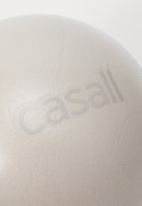 Ανοιχτό μπεζ μπάλα γυμναστικής με λεία, υφή επιφάνεια, που διαθέτει ένα διακριτικό ανάγλυφο λογότυπο "casall" από τη μία πλευρά.