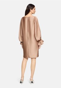 Satin braunes Kleid mit lockerem Schnitt, langen Puffärmel und gerader Saumlinie. Verfügt über eine subtile Rückennaht und eine glatte Textur.