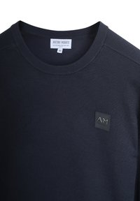 Tamno plavi pulover dugih rukava od mješavine viskoze, s okruglim izrezom i tkanim oznakom s logotipom na prsima.