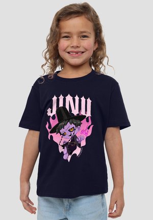 Smiling child with curly hair wears navy T-shirt featuring cartoon witch with hat, purple flames, and "JUNU" text on light gray background.