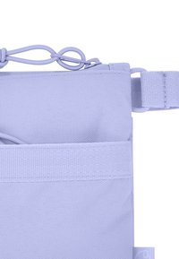 Sac en tissu violet clair avec une surface texturée, doté d'une fermeture à cordon et d'une large sangle. Comprend une poche extérieure sur un côté.