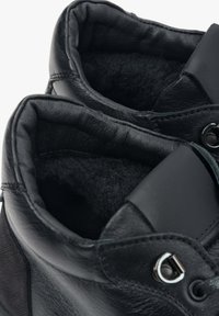 Czarne skórzane botki za kostkę z miękką, teksturowaną wyściółką. Charakteryzują się gładką powierzchnią, okućmi oczkowymi oraz kontrastowym panelem z tkaniny.