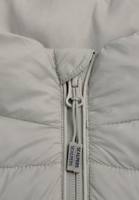White quilted jacket featuring a front zipper with a gray pull, embossed tab labeled "SCALPERS," and smooth, glossy texture.