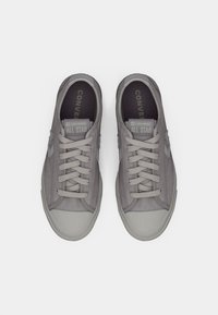 Pair of gray Converse All Star low-top sneakers with laces, viewed from above on a white background.