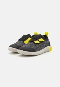 Czarne i szare dzianinowe sneakersy z żółtymi akcentami, wyposażone w rzepy, teksturowaną gumową podeszwę oraz okrągły czubek.