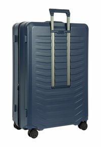 Hartschalentrolley in Marineblau mit horizontalen Rillen, ausziehbarem Teleskopgriff und vier schwarzen Rollen für Mobilität. Strapazierfähiges Material.