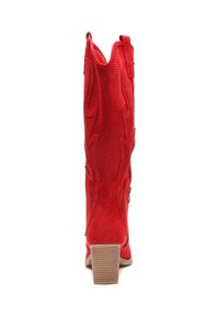 Bota vaquera roja con cuero perforado, punta afilada y tacón alto apilado. Presenta costuras decorativas y una pestaña en la parte superior.