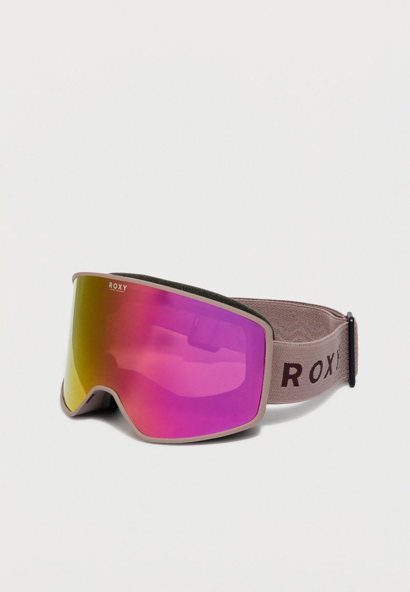 Ski brilles ar rozā un dzeltenu atstarojošu objektīvu, bēša rāmi un regulējamu bēša siksnu ar "ROXY" zīmolu uz baltā fona.