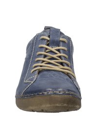 Chaussure en cuir bleu avec des lacets beiges, un bout arrondi, des coutures contrastées et une semelle en caoutchouc texturée. Design minimaliste sans embellissements.