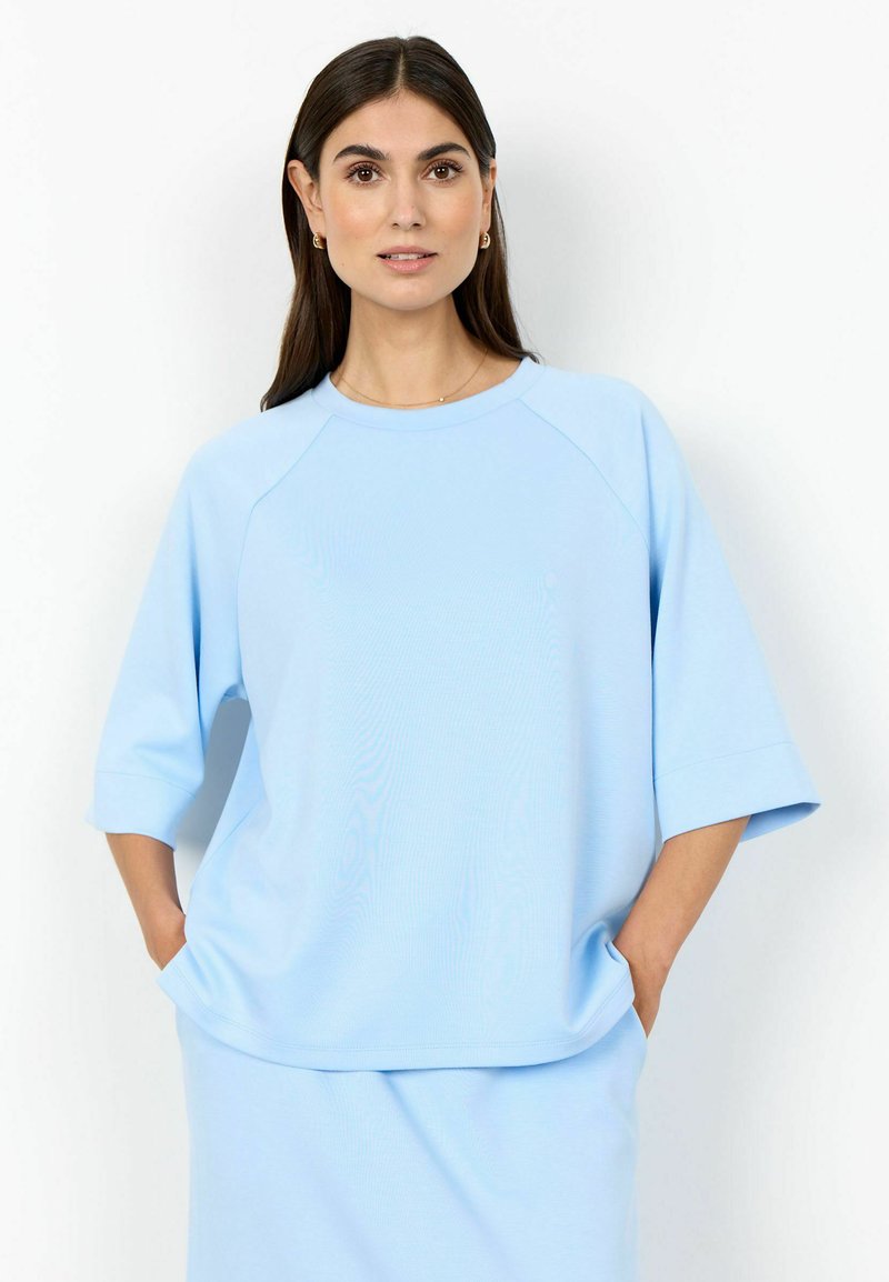Felpa oversize azzurro chiaro con maniche raglan 3/4 e scollo rotondo, caratterizzata da una texture morbida e liscia e una vestibilità rilassata.