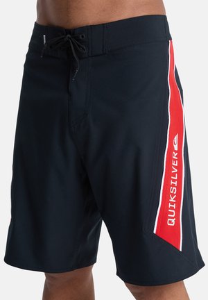 Czarne kąpielówki wykonane z teksturowanej tkaniny, z elastycznym paskiem w talii i sznurkiem do regulacji, z czerwono-białymi akcentami po bokach oraz logo "Quiksilver".