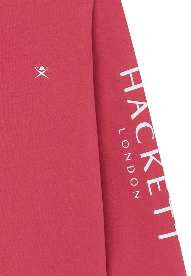 Camisa de manga larga roja de algodón. Presenta el texto y el logo blancos "HACKETT" en la manga. Textura suave con un corte relajado.