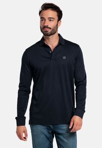 Marineblaues Langarm-Polohemd aus weichem Material, mit einem klassischen Kragen, zwei Knöpfen und einem gestickten Logo auf der Brust.