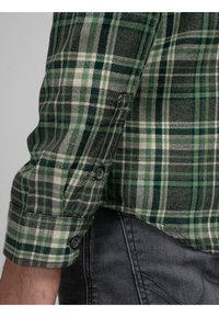 Camisa de franela a cuadros en verde y gris con puños abotonados, que presenta una tela texturizada y líneas blancas contrastantes en el patrón.