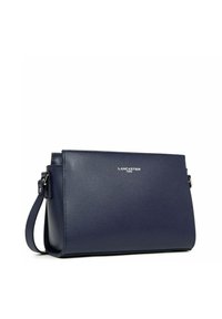 Borsa a tracolla in pelle blu navy con forma rettangolare, superficie texturizzata, tracolla regolabile e logo argento "Lancaster Paris" sul fronte.
