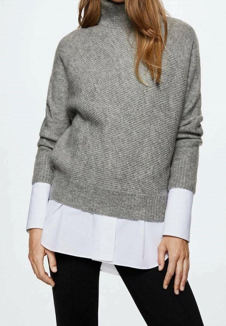Hellgrauer, gerippter Strickpullover mit hohem Kragen, über einem weißen Hemd getragen. Verfügt über eine entspannte Passform und eine leicht verkürzte Länge.
