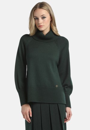 Maglione a maglia verde scuro con colletto alto a coste, maniche raglan e orlo a coste. Presenta un piccolo logo dorato in basso.