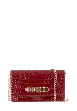 Rode nep krokodillenleren clutch met een glanzende afwerking, voorzien van een gouden kettingband en een decoratief gouden hardware detail aan de voorkant.