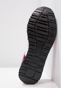 Černá gumová podešev s hlubokými drážkami, zdobená růžovým nástřikem a bílou stranou. Navržena pro trakci a odolnost.