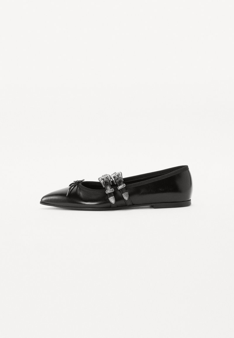 Black patent leather ballet flat with a pointed toe, adorned with two silver-tone buckles and a bow detail on the front.