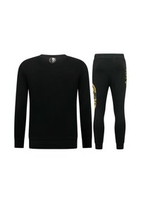 Zwarte set van sweatshirt en legging gemaakt van een gladde stof; heeft een ronde halslijn, geribbelde manchetten en een gouden ontwerpdetail op de legging.