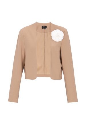 Beiger, kurz geschnittener Blazer mit langen Ärmeln und offenem Frontdesign, verziert mit einer großen weißen Stoffblüte auf der linken Brust.