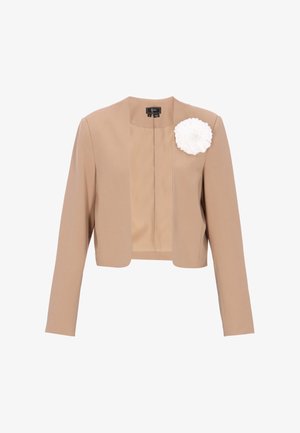 Beiger, kurz geschnittener Blazer mit langen Ärmeln und offenem Frontdesign, verziert mit einer großen weißen Stoffblüte auf der linken Brust.