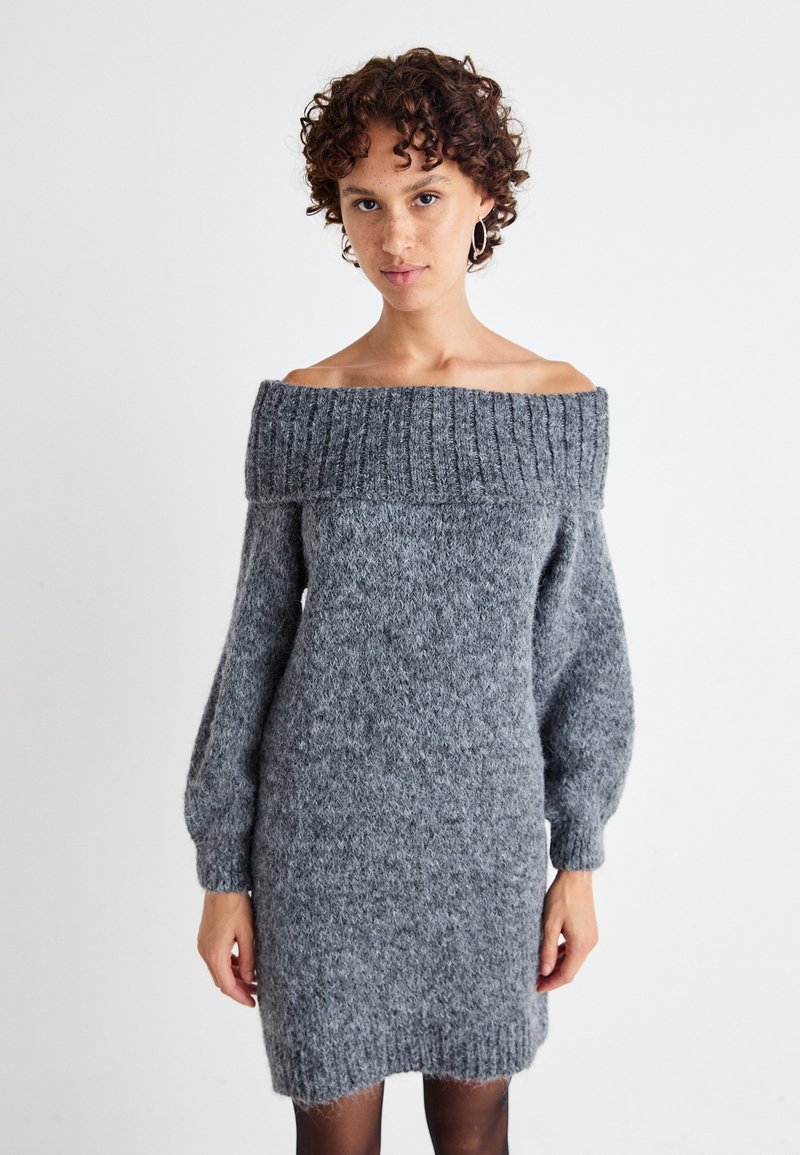 Hallituspuu hall off-the-shoulder kootud kleit, millel on ribitud kaelus ja pikad, veidi poufse varrukad. Pehme, tekstuuriga kangas, millel on keha külge järgnev siluett.