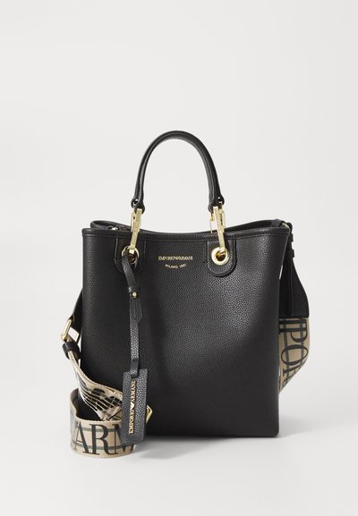 Borsa a secchiello in pelle nera con finitura texturizzata, hardware dorato e tracolla regolabile con motivo logo. Doppi manici per il trasporto.