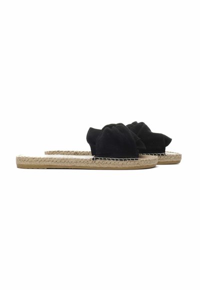 Sandali a scivolo in suede nera con un design superiore annodato, caratterizzati da una suola in juta intrecciata e una finitura testurizzata. Design piatto e aperto sul davanti.