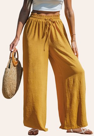 Bright yellow wide-leg pants made of textured fabric with an elastic waistband and adjustable drawstring, paired with a straw handbag.