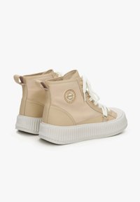 Beige hoge sneakers met een gestructureerde witte rubberen zool, voorzien van een rond logo aan de zijkant en witte veters. Gladde synthetische materialen.