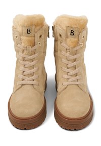 Béžové semišové kotníkové boty s umělým kožíškem, předním šněrováním a bočními zipy. Mají zlaté průchodky a hnědou gumovou podrážku.