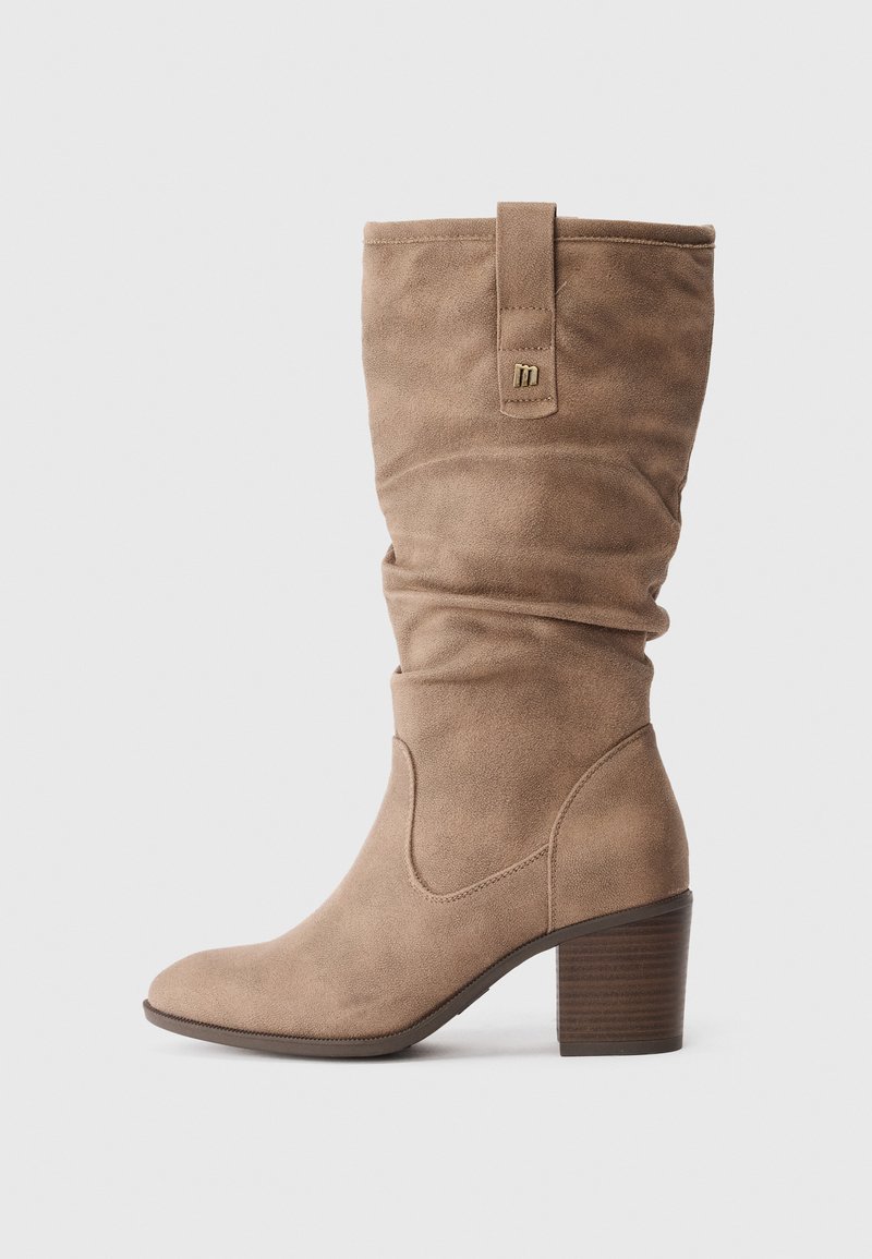 Bota alta de ante marrón con tacón apilado y diseño holgado, que presenta una pequeña etiqueta de acento en el lado exterior y una textura suave.