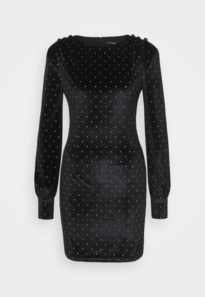 Abito in velluto nero con maniche puff lunghe, decorato con piccole macchie d'argento. Presenta un colletto rotondo e chiusura con zip sul retro.