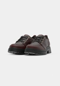 Pantofi din piele bordeaux cu sireturi negre, design cu vârf rotund, suprafață texturată și talpă groasă din cauciuc negru cu aderență.