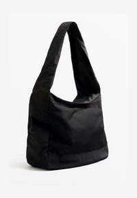 Zwarte schoudertas gemaakt van lichtgewicht, gestructureerde stof. Voorzien van een brede riem en een gaaspaneel voor extra stijl en ademend vermogen.