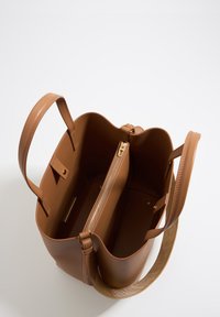 Brown leather tote bag with a zippered compartment and smooth texture. Features sturdy handles and an open top design for easy access.