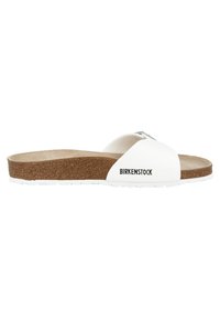 Sandales à glissière Birkenstock blanches avec une large sangle, semelle en liège et semelle en caoutchouc blanc texturé. Logo noir sur le côté.