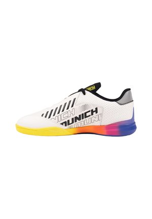 Zapatilla deportiva blanca con cordones negros, marca negra y suela degradada de amarillo a azul en vista lateral sobre fondo blanco.