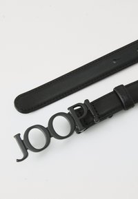 Black leather belt with a distinctive black logo buckle spelling "JOOP!" featuring smooth texture and flat strap design with stitching details.