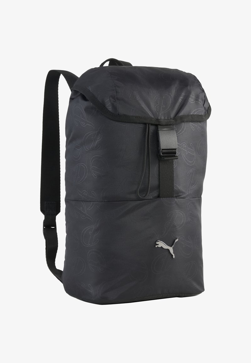 Sac à dos noir Puma avec rabat et fermeture à boucle, bretelles réglables et motifs embossés subtils. Logo Puma sur la poche avant.