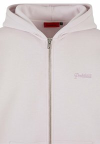 Felpa con zip di colore rosa chiaro in morbido cotone. Presenta una zip frontale, due tasche laterali e un piccolo logo ricamato "Proibito".