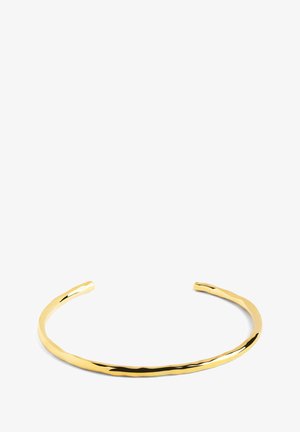 Zlatni metalni manžet s glatkim, blago uvijenim dizajnom. Ima elegantan, otvoreni oblik za prilagodljivo nošenje.