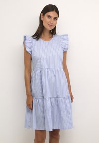 Prugasta obleka v svetlo modri in beli bombaž z kratkimi ruffled rokavi in večplastnim krojem krila. Prijetno prileganje z okroglim izrezom.